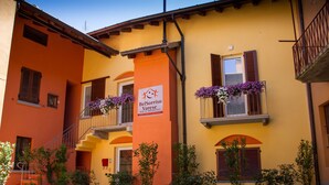 A building with a sign for BelSorriso Varese Bed & Breakfast, featuring a staircase, potted plants, and flower boxes on the windows. - Bel Sorriso Varese - Dormire Felice Rooms & Apartments (Varese)