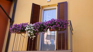 A balcony with a flower box containing purple and white flowers. - Bel Sorriso Varese - Dormire Felice Rooms & Apartments (Varese)