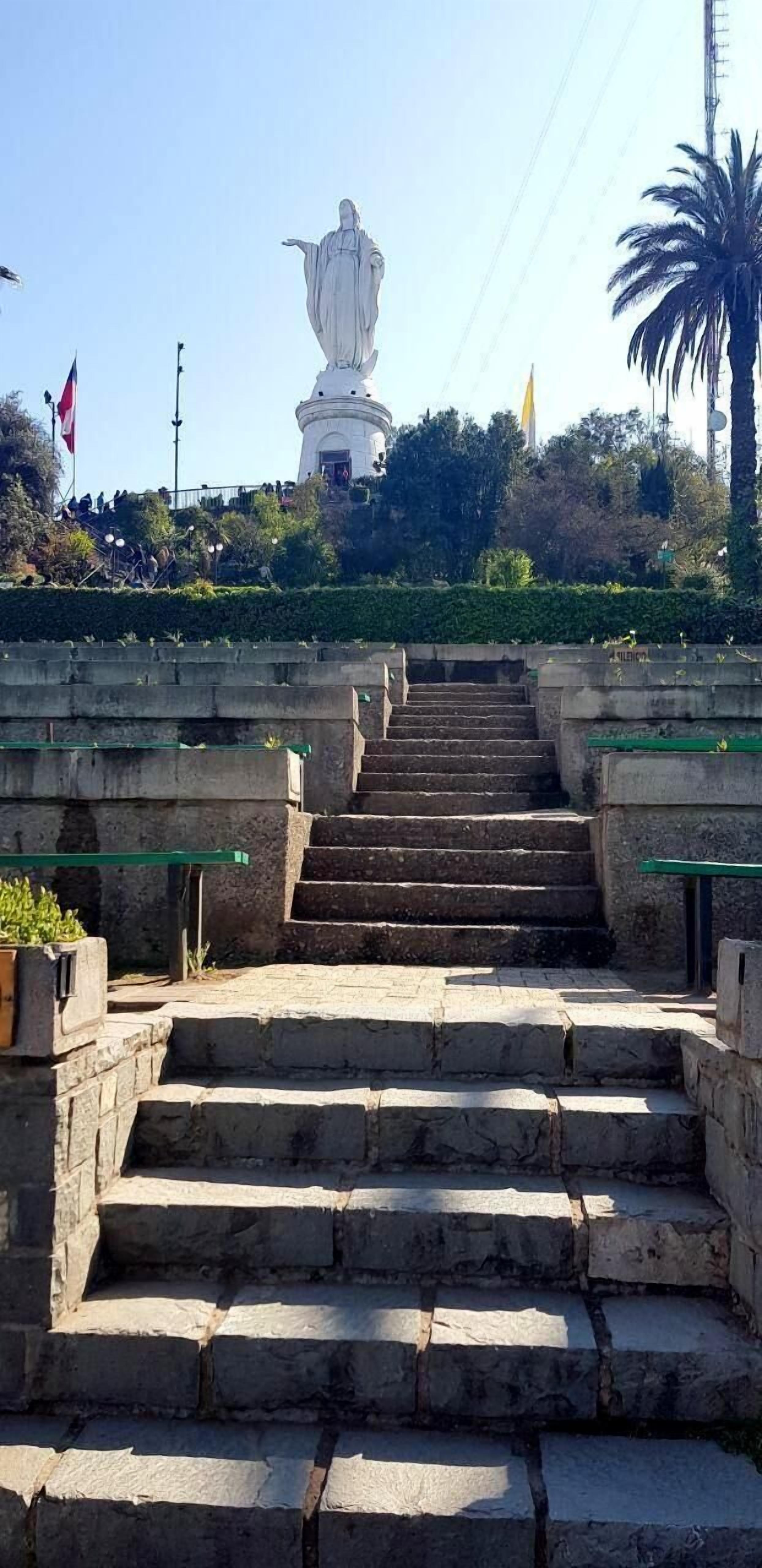 Un conjunto de escalones de piedra que conducen a una estatua blanca en una colina.