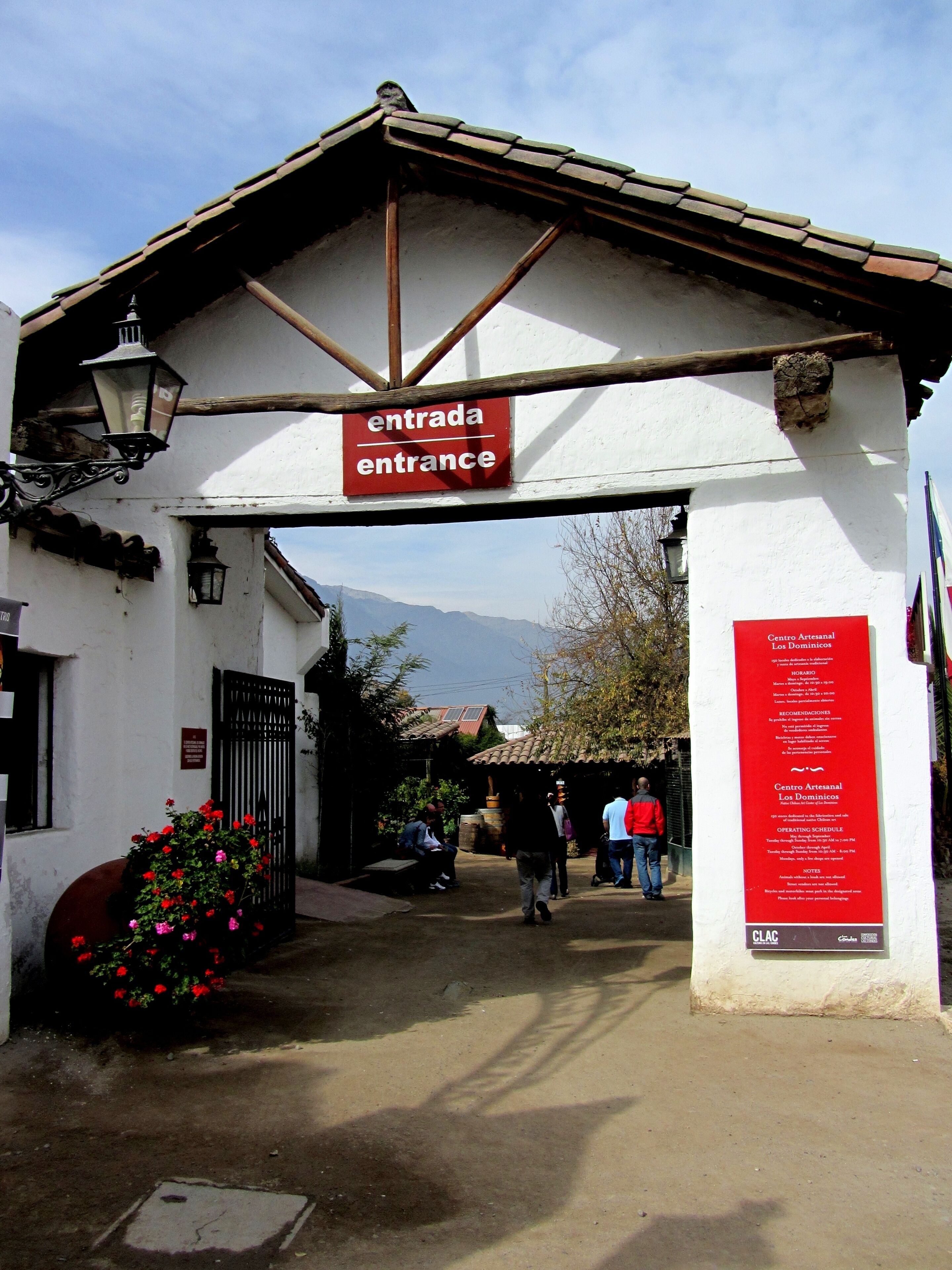 An entrance with a sign reading "entrada entrance" and a red informational board.