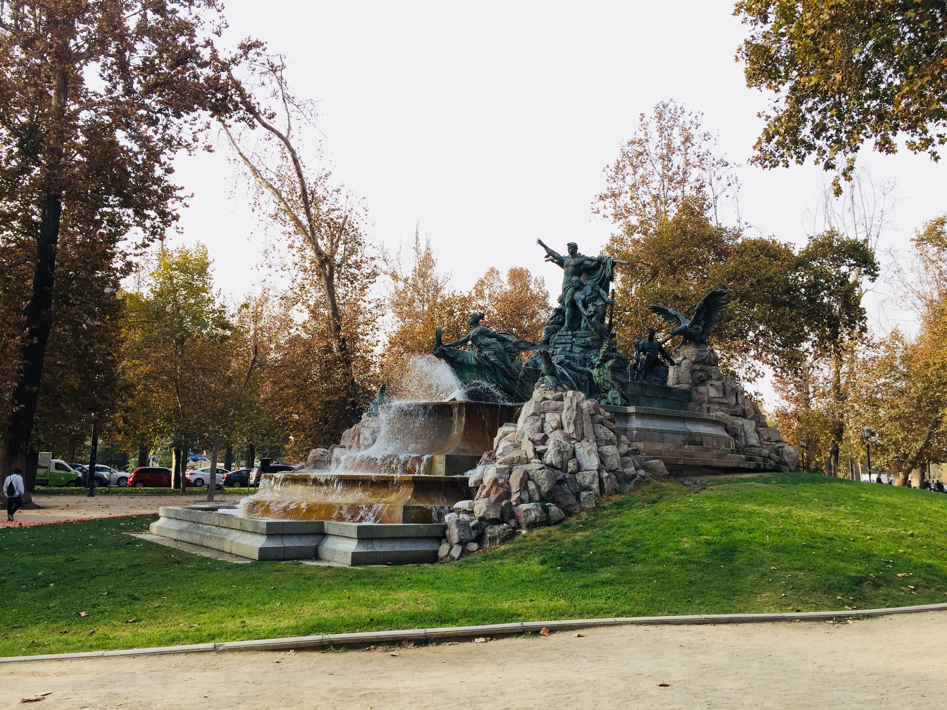 A park with a fountain and statues.