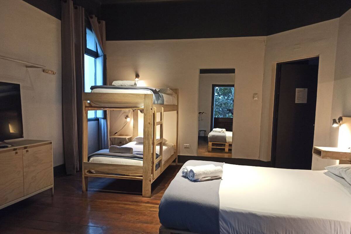 A bunk bed room with a desk and a bed.