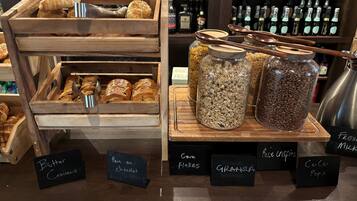 A bakery display with pastries and labeled jars of granola and other ingredients.