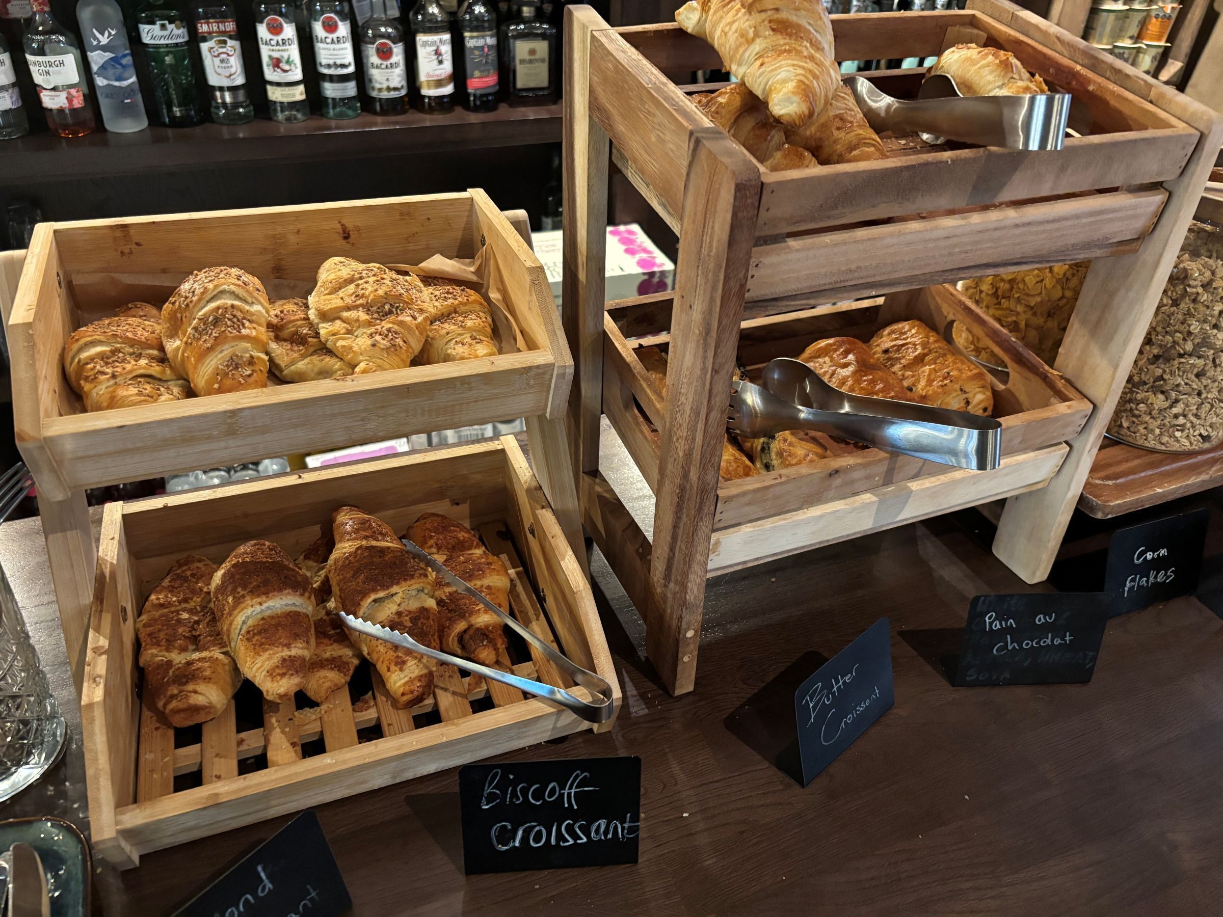 Houten vitrines met gebak en een bord waarop 'Biscuit Croissant' staat.