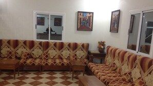 Una sala de estar con piso a cuadros, sofás estampados y una mesita.