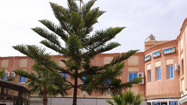 Un edificio con un cartel que indica 'Motel Paris' y 'Dakar', señalando un hotel.