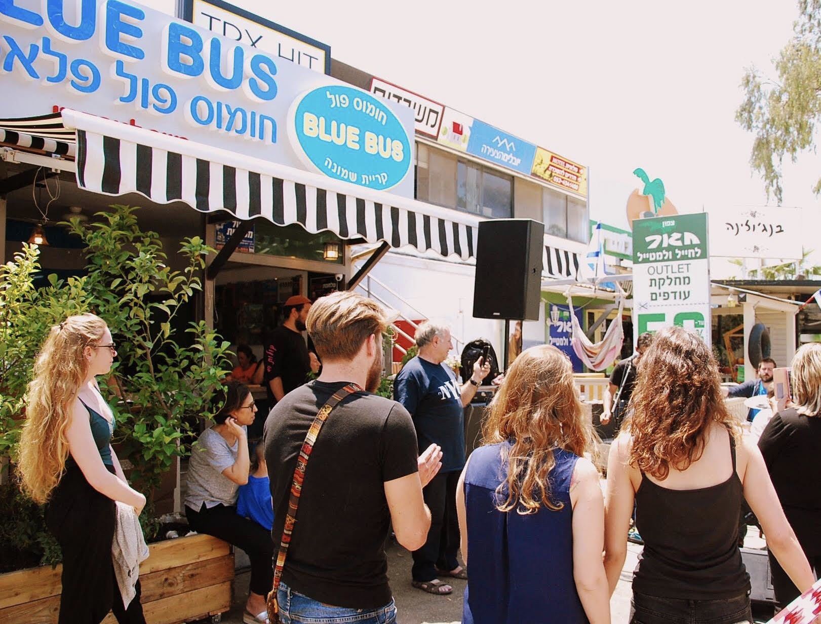 A busy outdoor market with various stalls and people.