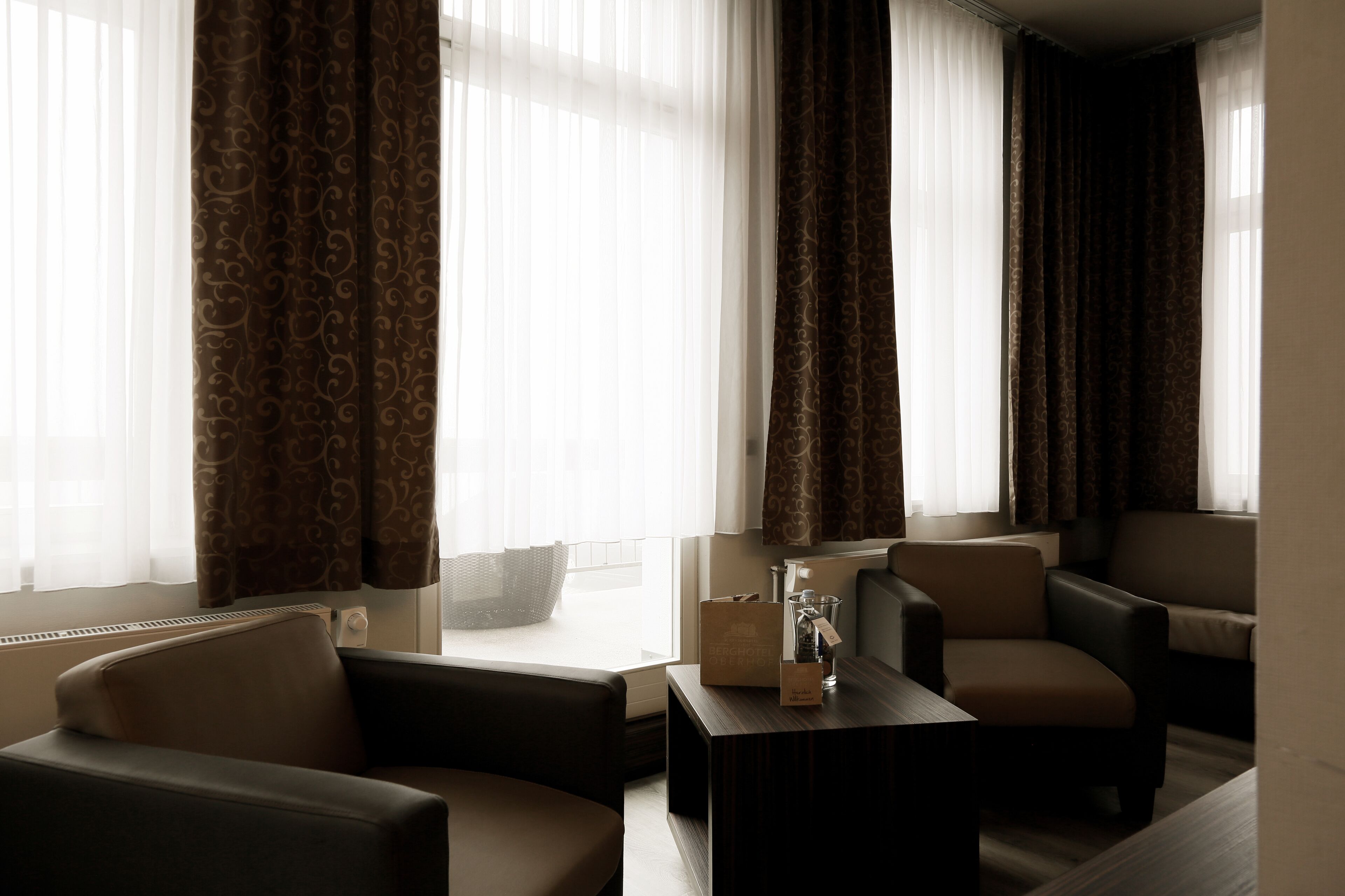 A living room with two sofas, a coffee table, and a window with curtains.