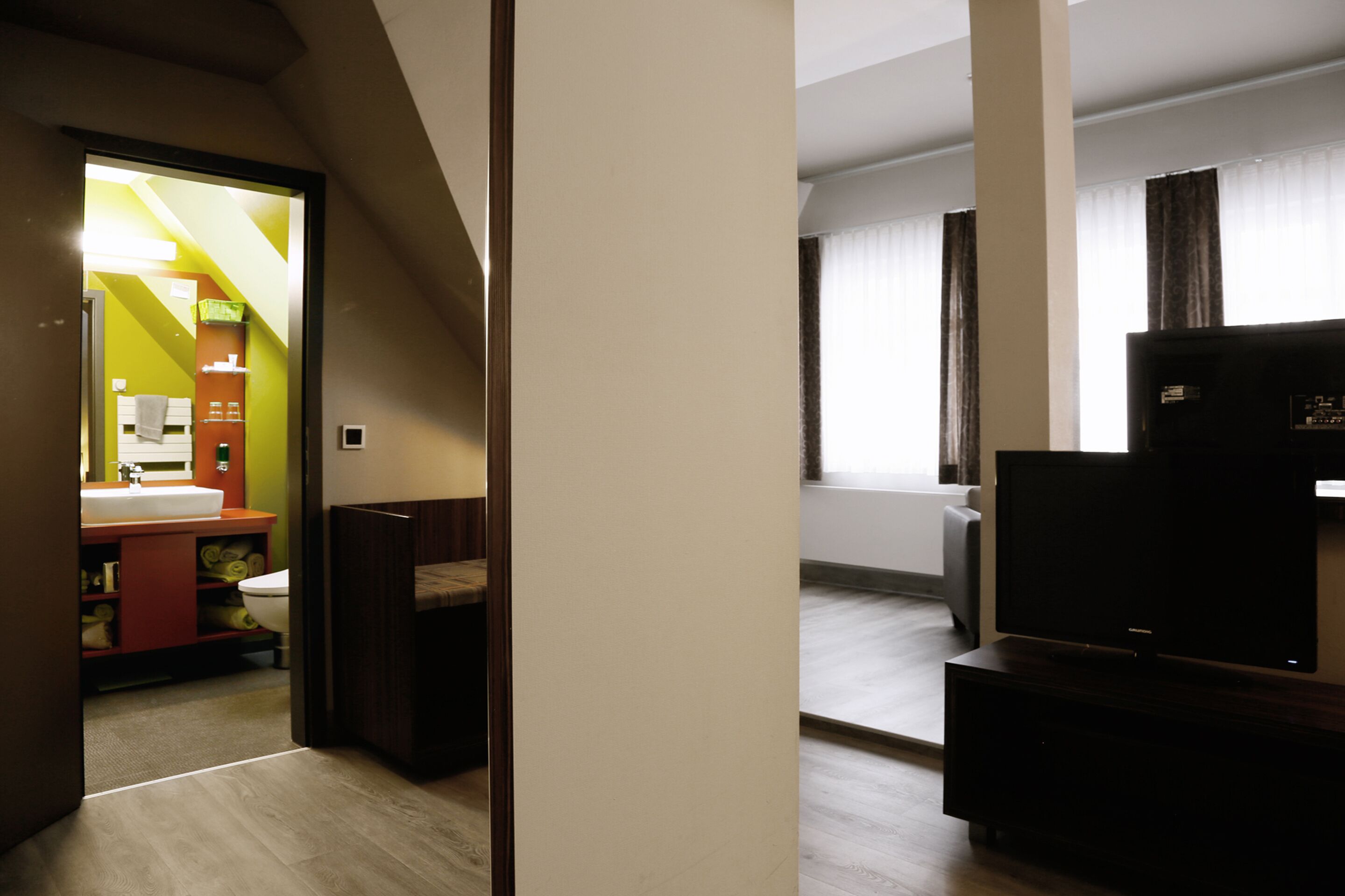 Een modern appartement met keuken, een woonkamer met flatscreen-tv en een badkamer.