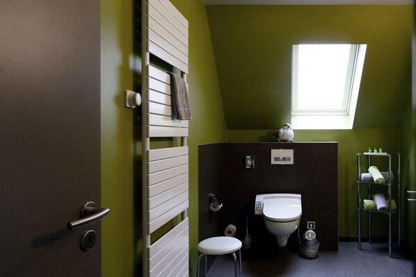 Une petite salle de bain comprenant des toilettes, un lavabo et un porte-serviettes.