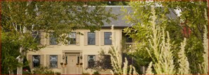 A two-story house with a front porch, a garage, and a small front yard.