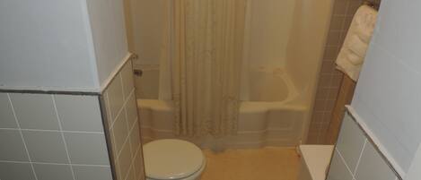 Un baño pequeño con inodoro, bañera y cortina de ducha.