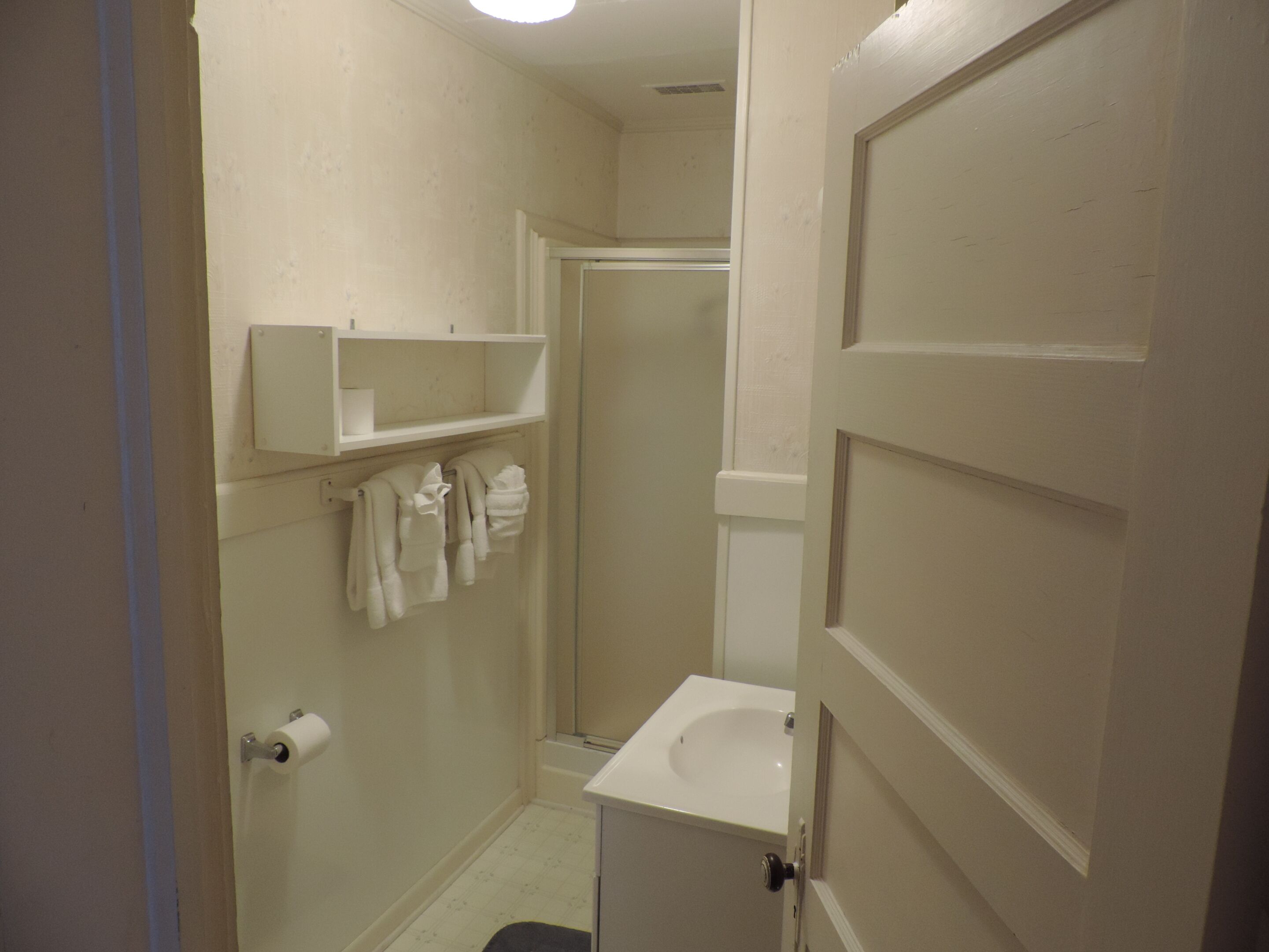 Un baño pequeño y limpio, con inodoro, lavamanos y barra para toallas.