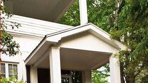 A two-story house with a covered porch and a brick column. - Franklin Terrace Bed and Breakfast (Franklin)