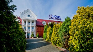 Un hotel con techo rojo, columnas blancas y un letrero que dice "Hotel Groman".