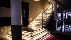 Una imponente escalera con escalones iluminados y barandilla, que conduce a un nivel superior.