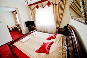 A hotel room with a large bed, a television, and a mirror. - Hotel Groman (Raszyn)