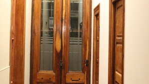 A wooden double door with glass panels and a metal handle. - Eclat Suites (Villa Mercedes)