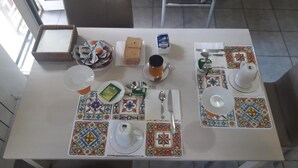 A dining table set with plates, cutlery, a glass, and condiments. - Garden of Rome Guesthouse (Rome)