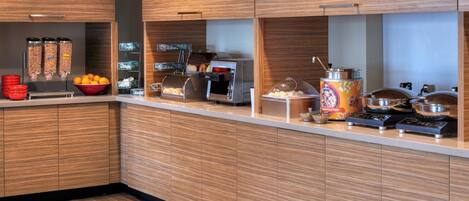 A modern kitchen with a built-in coffee station, a bread display, and various food containers.