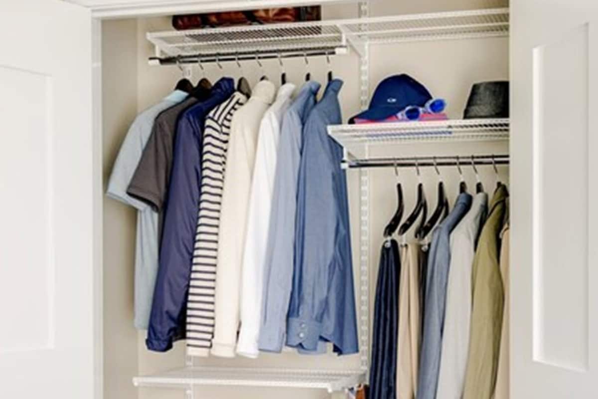 A walk-in closet with shelves for folded clothes, a rack for hanging items, and a shoe rack.