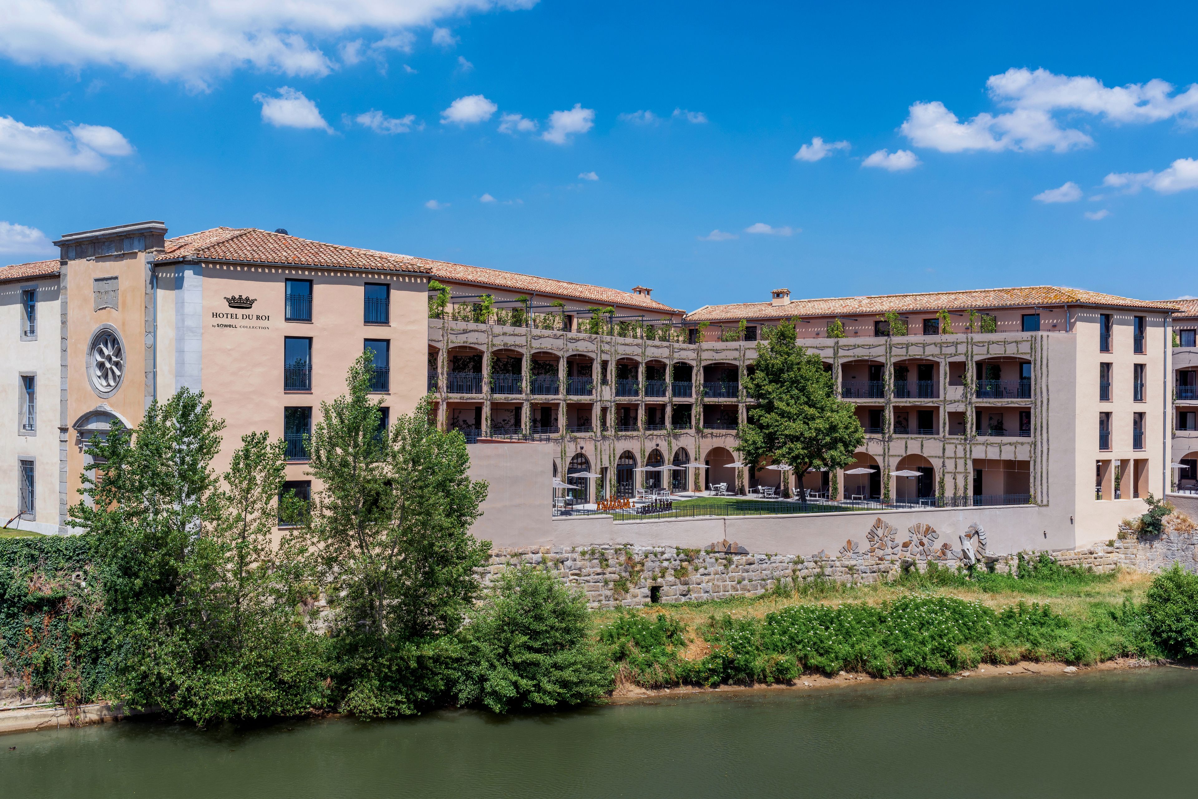 Un hôtel doté d’une cour intérieure, de sièges en plein air et offrant une vue sur la rivière.