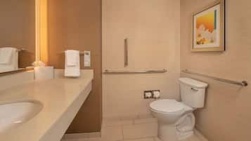 Une salle de bain moderne équipée d’un lavabo, de toilettes et d’une barre d’appui.