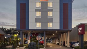 A hotel with a modern facade, multiple floors, and a covered parking area. - TownePlace Suites by Marriott Tampa South (Tampa)