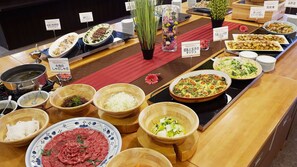 A buffet with various dishes and ingredients displayed on a counter.