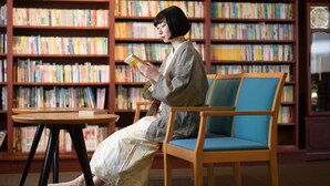 A person seated in a library with bookshelves in the background. - Yamadake Onsen Resort Shin Tamagawa Onsen (Senboku)