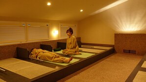 A room with tatami mats, a bed, and a person sitting on a mat. - Yamadake Onsen Resort Shin Tamagawa Onsen (Senboku)