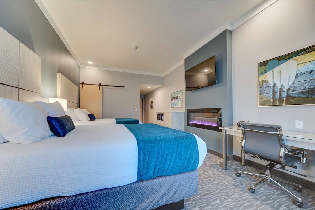 Une chambre d’hôtel avec un grand lit, un bureau et une chaise.