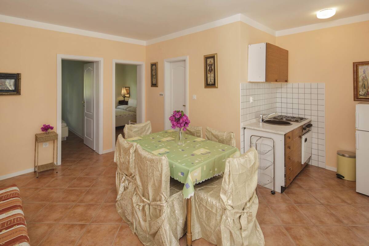 Un espacio habitable compacto con comedor, cocina y un dormitorio visible.