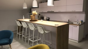 A modern kitchen with a central island, bar stools, and pendant lighting. - Villa Tamara (Jelsa)