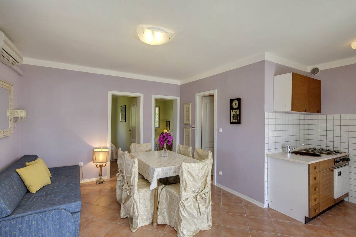 Un espacio habitable compacto con comedor, kitchenette y sofá.