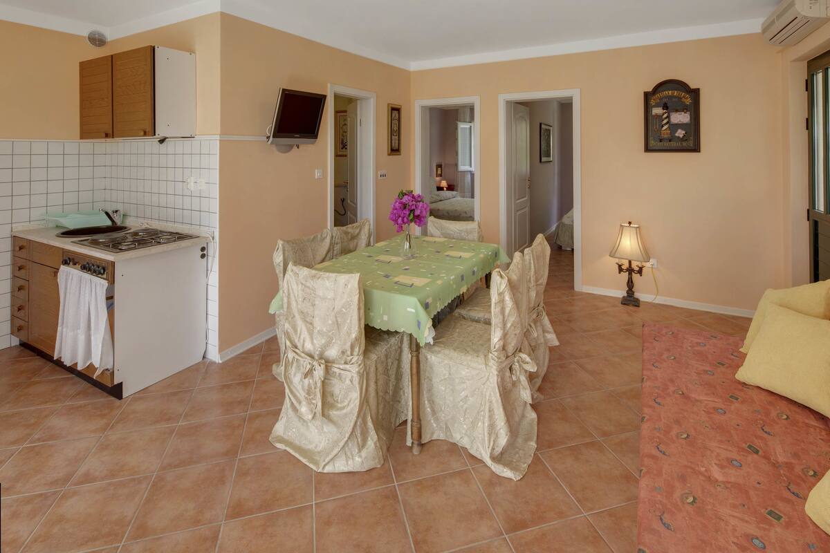 Cocina compacta con comedor, una pequeña isla y un sofá.