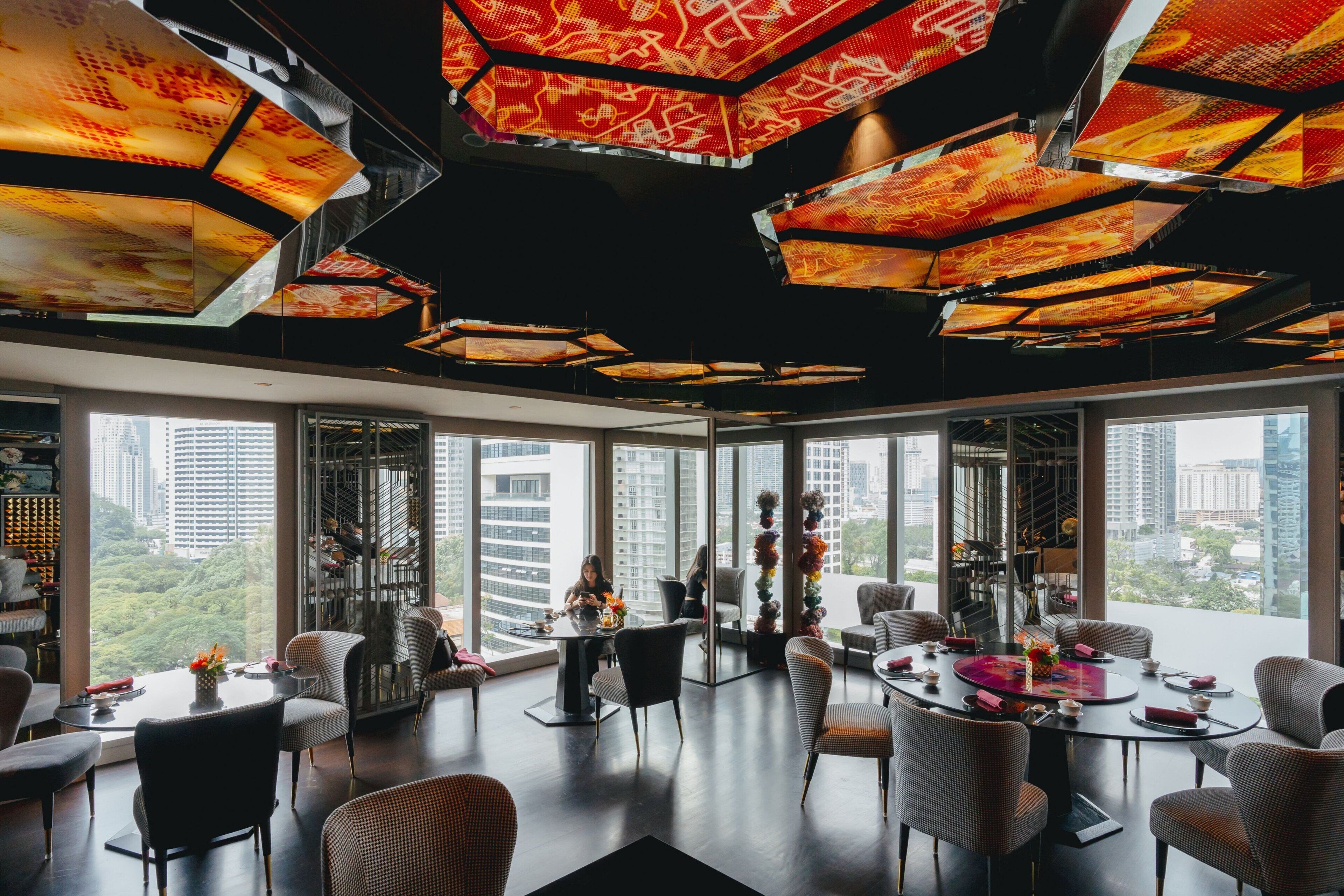 Un comedor moderno con techos altos, ventanas amplias y vistas a la ciudad.
