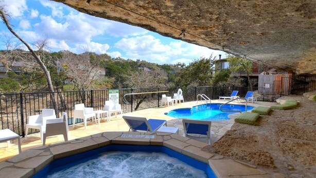 A hot tub area with lounge chairs and a pool.