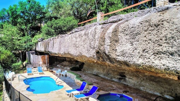 A pool area with two hot tubs and lounge chairs. - Cool Treehouse Cabin for wake sport and boating with cave pool [#12 Honeysuckle] (Lakeway)