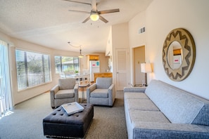 A living room with a sofa, two armchairs, a coffee table, and a ceiling fan. - Texas Star #13 - Treehouse Retreat with Pool Access (Lakeway)