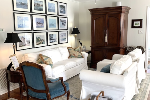 Living room with comfortable seating for 4, streaming TV and lots of DVDs.