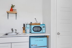 A kitchen with a sink, a coffee maker, a microwave, and a Galanz refrigerator.