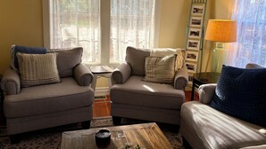 A cozy living room with two armchairs, a coffee table, and a lamp.