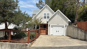 A two-story house with a garage, a wooden deck, and a fenced yard.
