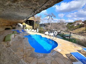 An outdoor swimming pool with lounge chairs and a no diving sign.