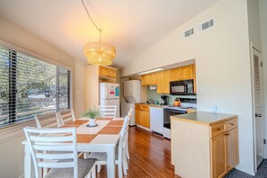 A compact kitchen with wooden cabinets, a microwave, and a refrigerator. - Midweek waterfront heaven near Austin with pool and hot tub [#5 Rain Lily] (Lakeway)