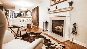A living room with a fireplace, a cowhide rug, and a painting on the wall. - Luxurious Franklin Experience! 5min To Downtown   (Franklin)