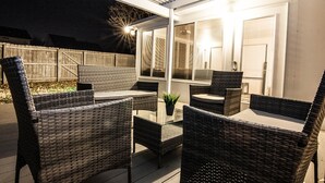 An outdoor patio area with wicker furniture and a glass table. - Luxurious Franklin Experience! 5min To Downtown   (Franklin)