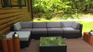 A log cabin with a large sectional sofa, a small table, and a decorative bowl on a wooden stand. - perfect getaway near sylvan beach! 2 night minimum (Blossvale)
