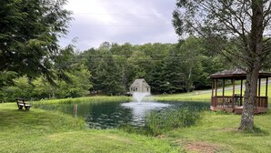 Un kiosque, un étang et un banc dans un parc.